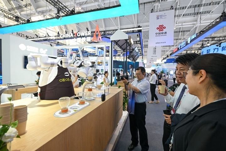 6月20日，與會(huì)者品嘗機(jī)器人沖調(diào)出的咖啡。新華社記者 孫凡越 攝