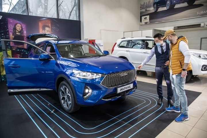 2021年4月1日，銷售人員在哈薩克斯坦阿拉木圖市經(jīng)銷商店向消費(fèi)者介紹哈弗汽車。新華社發(fā)（阿斯塔納汽車公司供圖）