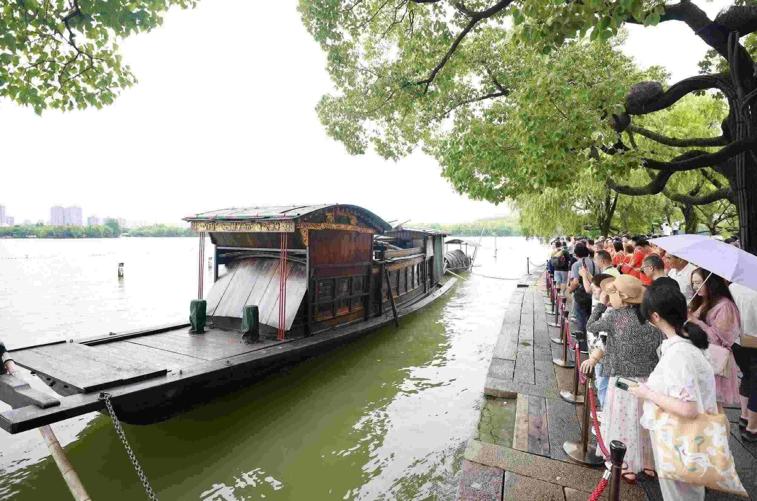浙江嘉興，游客在南湖景區(qū)湖心島瞻仰紅船，感悟“紅船精神”。（圖片來源：視覺中國(guó)）
