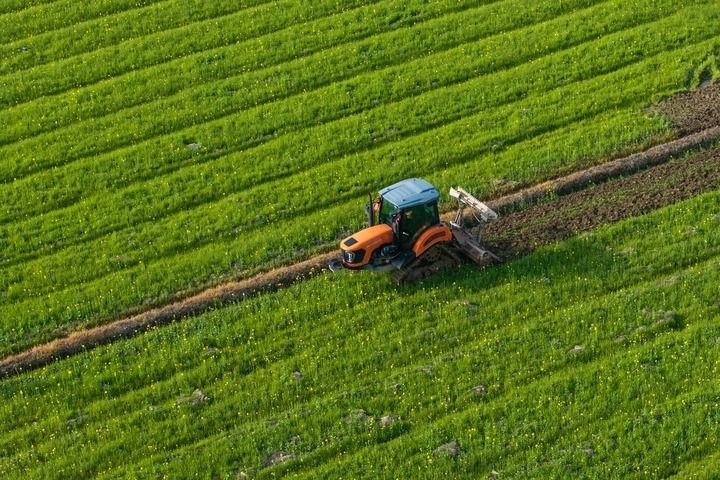2024年3月19日，在湖南省常德市鼎城區(qū)謝家鋪鎮(zhèn)港中坪村，村民駕駛農(nóng)機(jī)翻耕田地（無人機(jī)照片）。新華社記者 陳思汗 攝