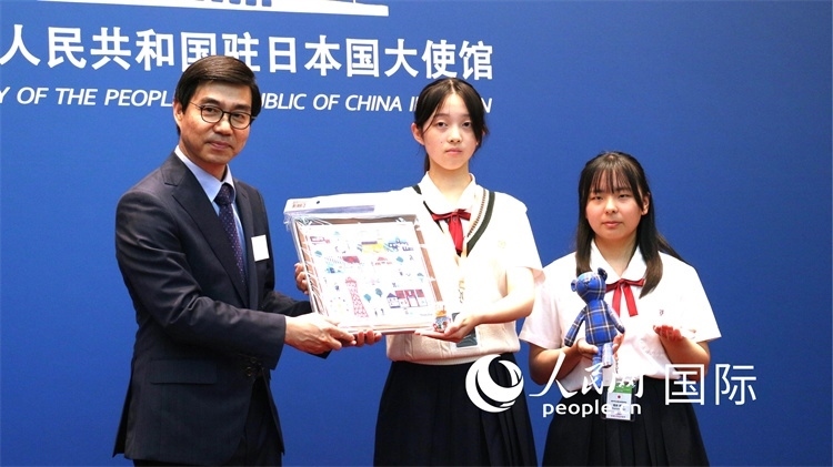 日本小大使向中國(guó)駐日本大使館臨時(shí)代辦施泳贈(zèng)送當(dāng)?shù)靥厣Y品。人民網(wǎng) 許可攝