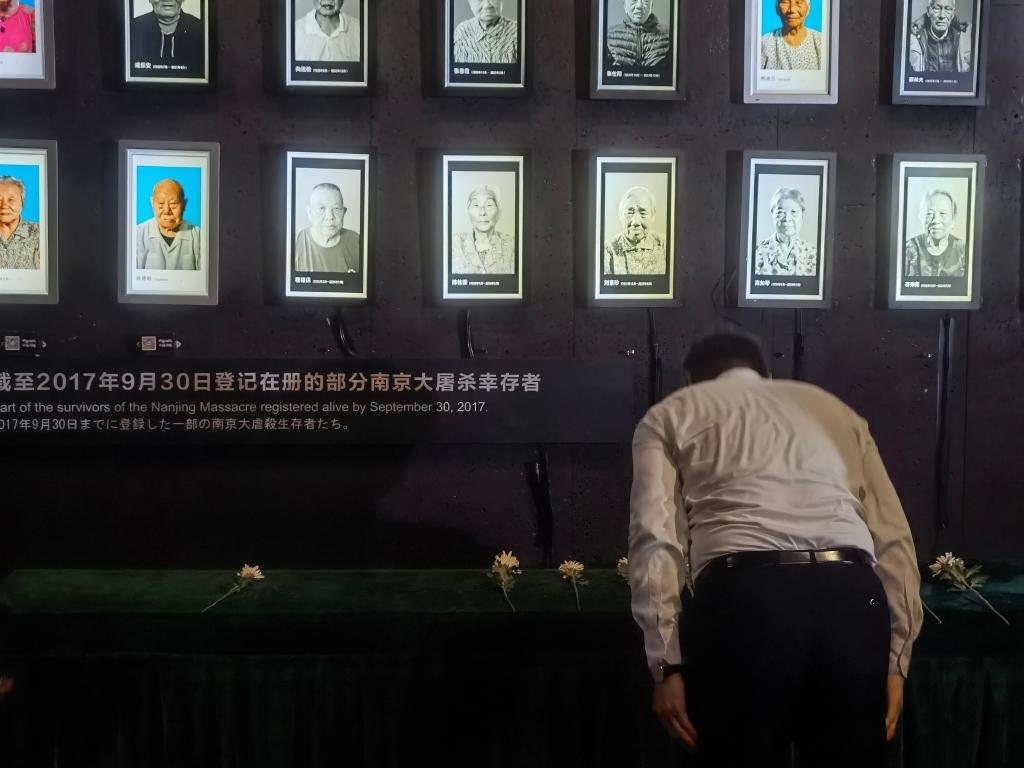 7月18日，人們向離世的南京大屠殺幸存者獻花、鞠躬。新華社記者邱冰清 攝
