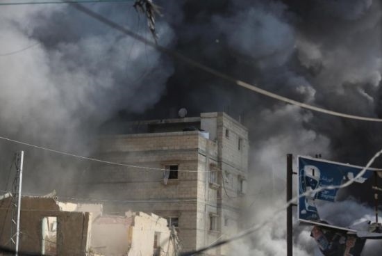 7月21日，在加沙地帶中部的努賽賴特難民營，遭以軍空襲的建筑冒出滾滾濃煙。新華社發(fā)（馬爾萬·達烏德攝）