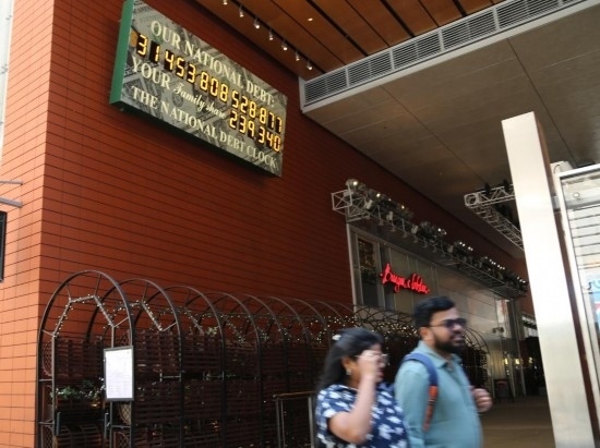 2023年5月29日，人們經(jīng)過美國紐約曼哈頓的“國債鐘”?！皣鴤姟笔且粋€大型計數(shù)器，它實時更新美國的公共債務(wù)總額，并顯示出每個美國家庭所要負(fù)擔(dān)的數(shù)額。 新華社記者劉亞南攝