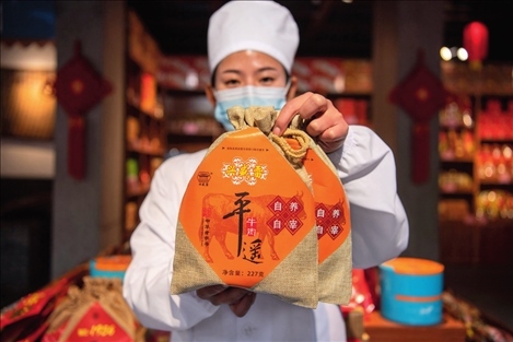 在位于山西省晉中市平遙縣的平遙古城南大街的一家平遙牛肉店內(nèi)，工作人員展示一款牛肉產(chǎn)品（資料照片）楊晨光攝 / 本刊