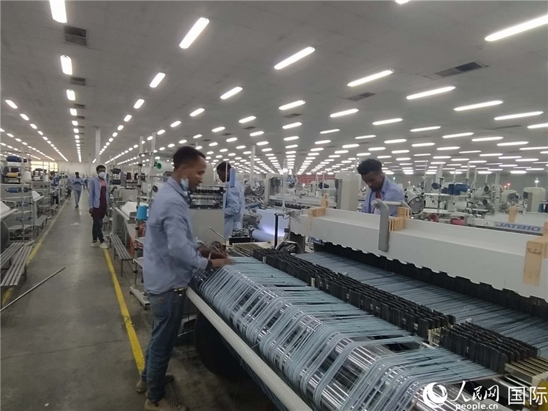 無錫金茂埃塞面料廠車間內(nèi)，當?shù)毓と苏谝唤z不茍地作業(yè)。人民網(wǎng)記者 黃培昭攝