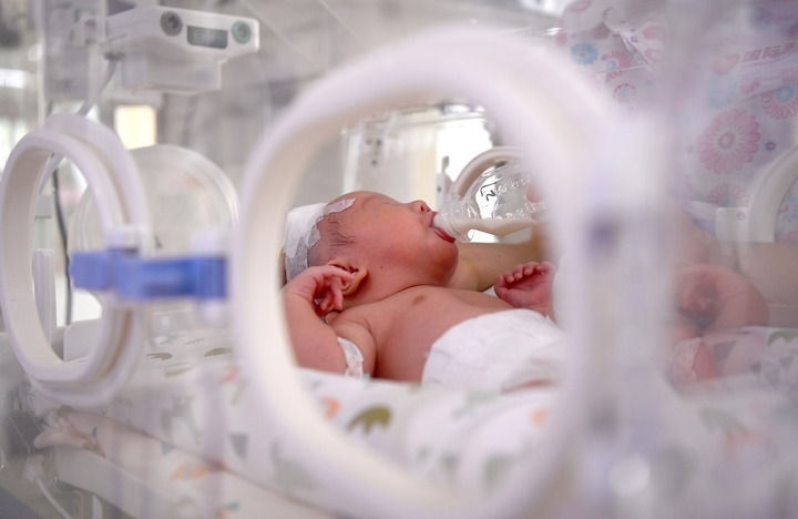 2024年6月1日，在西安國(guó)際醫(yī)學(xué)中心醫(yī)院新生兒科病房，護(hù)士為新生兒喂奶。 新華社記者 劉瀟 攝