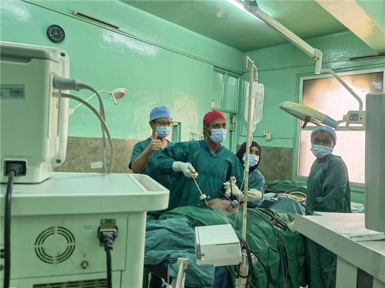 隊長蔣國慶（左一）關(guān)注當(dāng)?shù)蒯t(yī)生手術(shù)情況。中國援桑醫(yī)療隊供圖