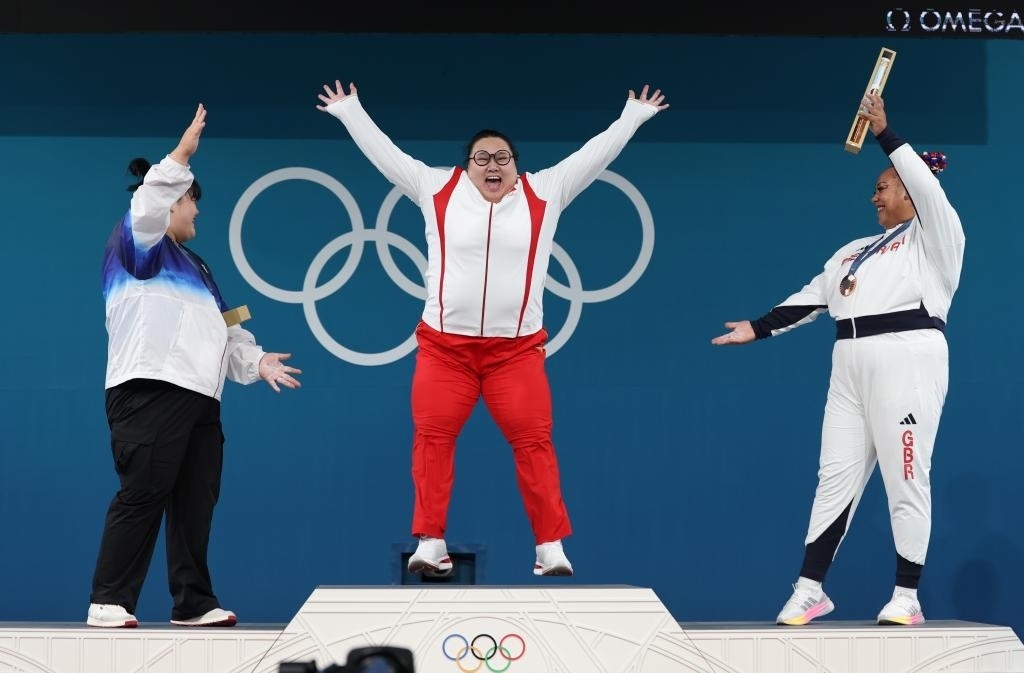 中國(guó)選手李雯雯（中）在巴黎奧運(yùn)會(huì)舉重女子81公斤以上級(jí)頒獎(jiǎng)儀式中登上領(lǐng)獎(jiǎng)臺(tái)（2024年8月11日攝）。新華社記者 楊磊 攝