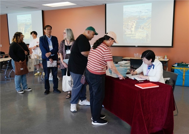 作者顧春芳在活動現(xiàn)場簽名贈書。羅先勇攝