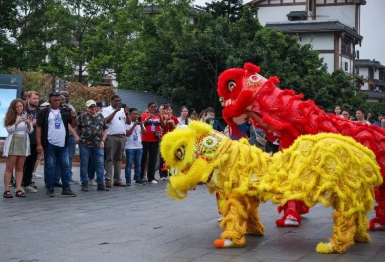 2024“一帶一路”媒體合作論壇聯(lián)合采訪調(diào)研行成員在樂山蘇稽古鎮(zhèn)觀看非遺舞獅表演。本報記者 伊霄攝