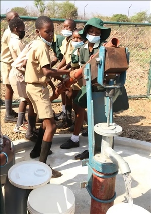 △2021年11月，在津巴布韋南馬塔貝萊蘭省省會(huì)關(guān)達(dá)的塞農(nóng)多小學(xué)，學(xué)生從中國(guó)援建水井里打水。