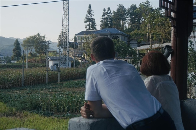 望得見山，看得見水，記得住鄉(xiāng)愁。每個人心中都有一個屬于自己的“花茂村”，在這方心田，走遍千山萬水，鄉(xiāng)音未改鬢毛衰。吉爾吉斯斯坦《比什凱克晚報(bào)》第一副總編輯妮娜·尼奇博洛娃與《中國與俄羅斯》雜志社社長奧列格·別列日內(nèi)赫攝在花茂村民居屋檐下并肩佇立，眺望山水，尋覓鄉(xiāng)愁。（李光裕攝）