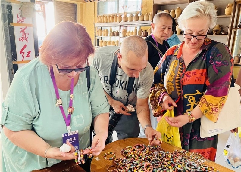 歐亞媒體考察團(tuán)成員在母氏陶藝館內(nèi)挑花了眼，色彩絢麗、質(zhì)地均勻的陶藝手串讓他們愛不釋手?！斑@里的東西都太實(shí)惠了！”塔吉克斯坦《索格特真理報(bào)》政論部主任娜塔利婭·多羅費(fèi)耶娃說?；宓奶厣a(chǎn)品物美價(jià)廉，讓考察團(tuán)成員為家人好友買到了心儀的禮物，也為此次以四川成都為起點(diǎn)，路經(jīng)南充、廣安至貴州遵義的考察行程畫上了圓滿句號。（張亞欣攝）