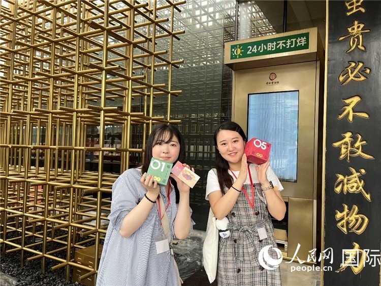 5. 代表團(tuán)團(tuán)員展示通過(guò)無(wú)人售藥機(jī)購(gòu)買的盲盒。（人民網(wǎng)記者陳思 攝）