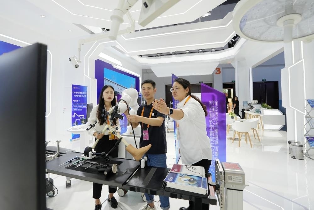 9月11日，一位媒體記者（中）在2024年服貿(mào)會國家會議中心會場體驗北京納通科技集團有限公司的膝關(guān)節(jié)置換手術(shù)機器人。新華社記者鞠煥宗 攝
