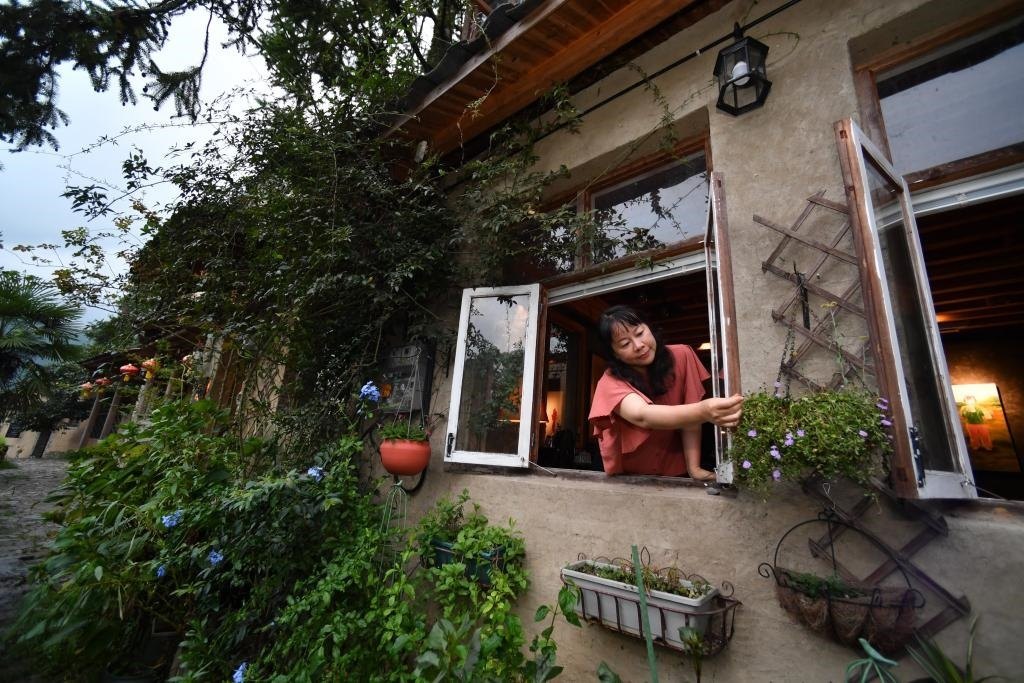 8月29日，在福建省屏南縣熙嶺鄉(xiāng)，龍?zhí)洞濉靶麓迕瘛泵泛暝诖蚶碜约航?jīng)營的民宿外墻裝飾花盆。新華社記者姜克紅 攝