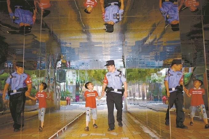 ?7月16日，重慶市公安局江北區(qū)分局一名民警在巡邏途中遇到一個(gè)獨(dú)自玩耍的小男孩，民警將其送回家。王洪平攝