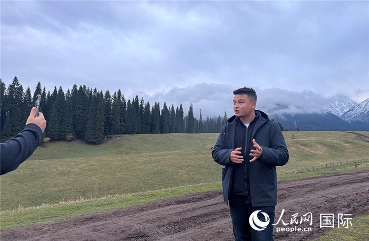 在庫爾德寧，吾買爾江被雪山美景震撼，即興錄制了短視頻作品。人民網(wǎng)記者曾書柔攝