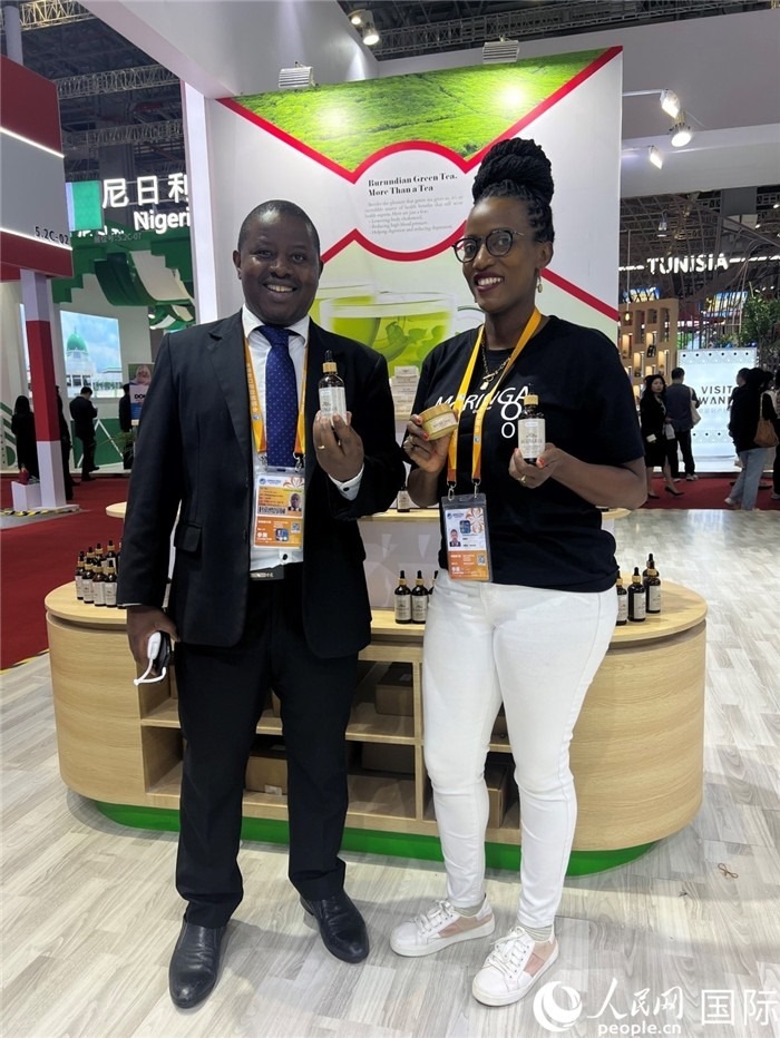 6月6日，布隆迪駐華大使館一等參贊布利馬索·阿爾弗雷德 (左，Bulimaso Alfred) 和參展商卡馬里扎·埃斯特拉 (Kamariza Estella) 在第七屆中國(guó)國(guó)際進(jìn)口博覽會(huì)布隆迪館展示當(dāng)?shù)厣a(chǎn)的辣木油。（人民網(wǎng) 艾里士 攝）