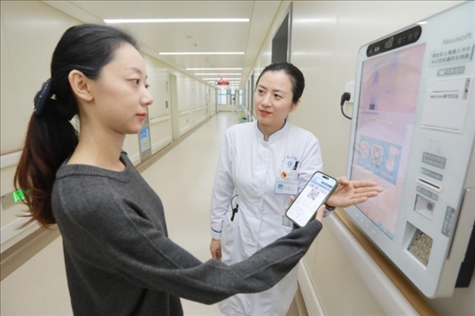 醫(yī)護(hù)人員引導(dǎo)患者在自助機(jī)前辦理自助入院手續(xù)。圖片來源：山東第一醫(yī)科大學(xué)第二附屬醫(yī)院