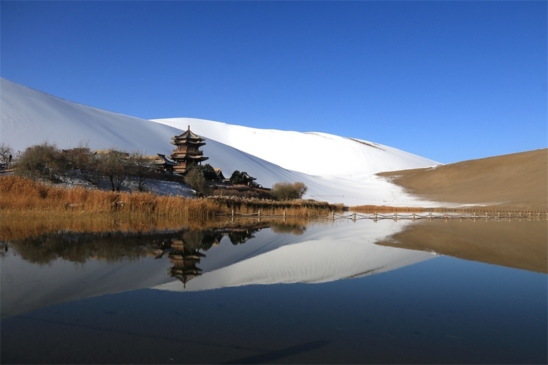 鳴沙山月牙泉景區(qū)雪景。敦煌市委宣傳部供圖，張曉亮攝