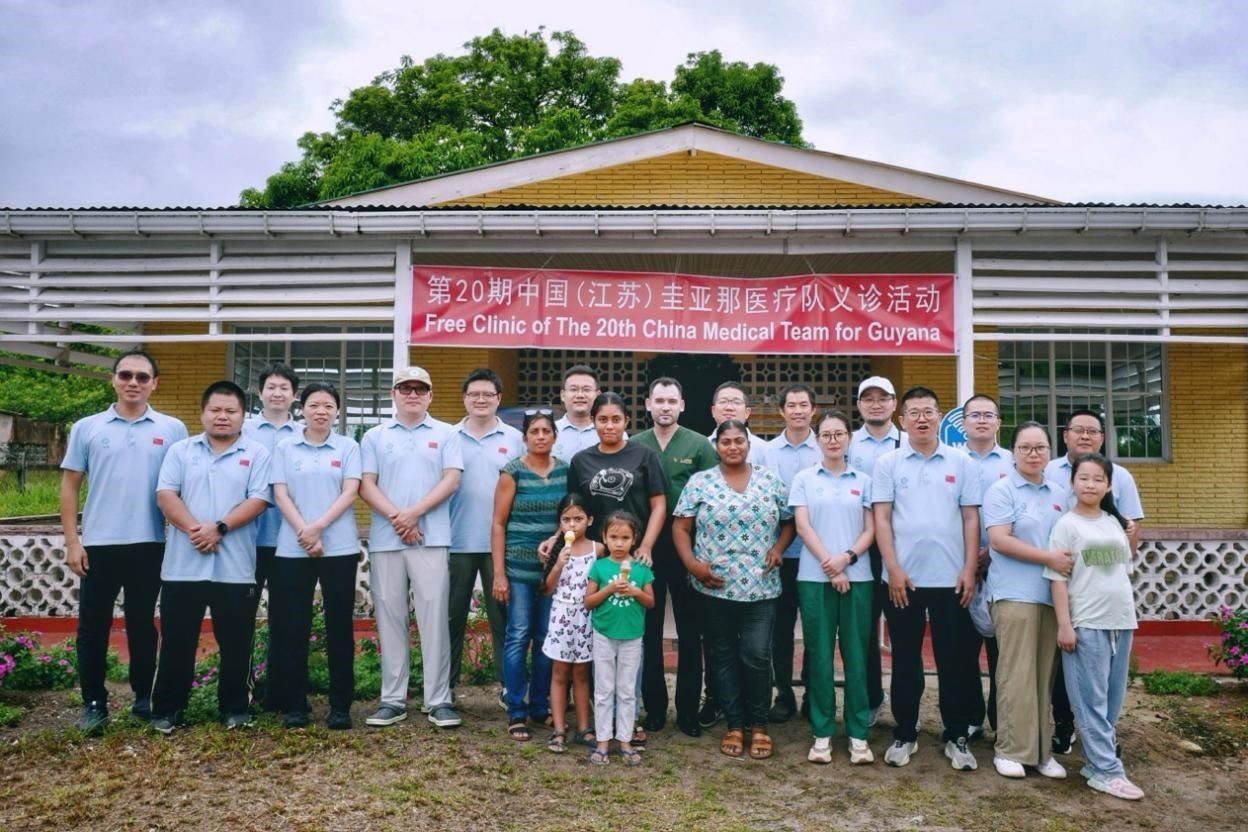 第20期中國(guó)（江蘇）援圭亞那醫(yī)療隊(duì)在圭偏遠(yuǎn)的林登高速社區(qū)開展義診后，與部分當(dāng)?shù)鼐用窈嫌啊?中國(guó)援圭醫(yī)療隊(duì)供圖