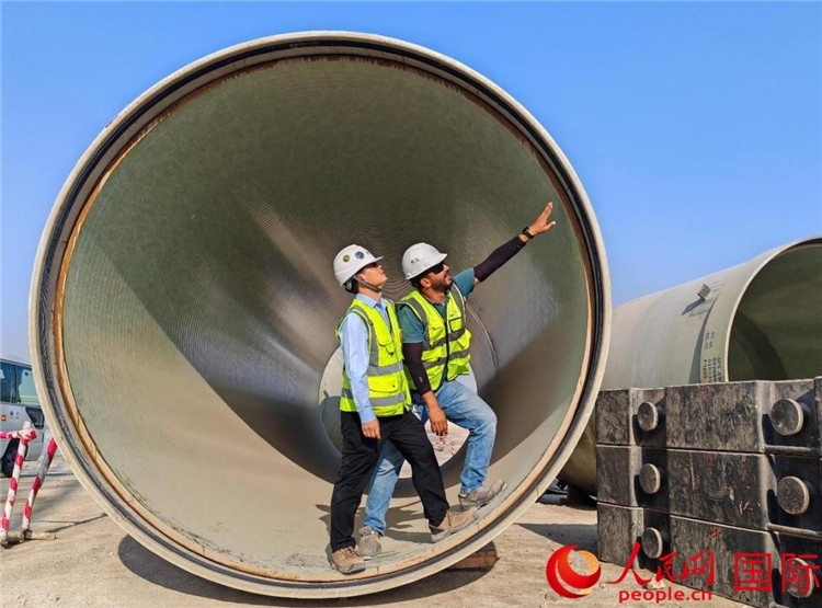 工作人員在察看輸水管情況。人民網(wǎng)記者 管克江攝
