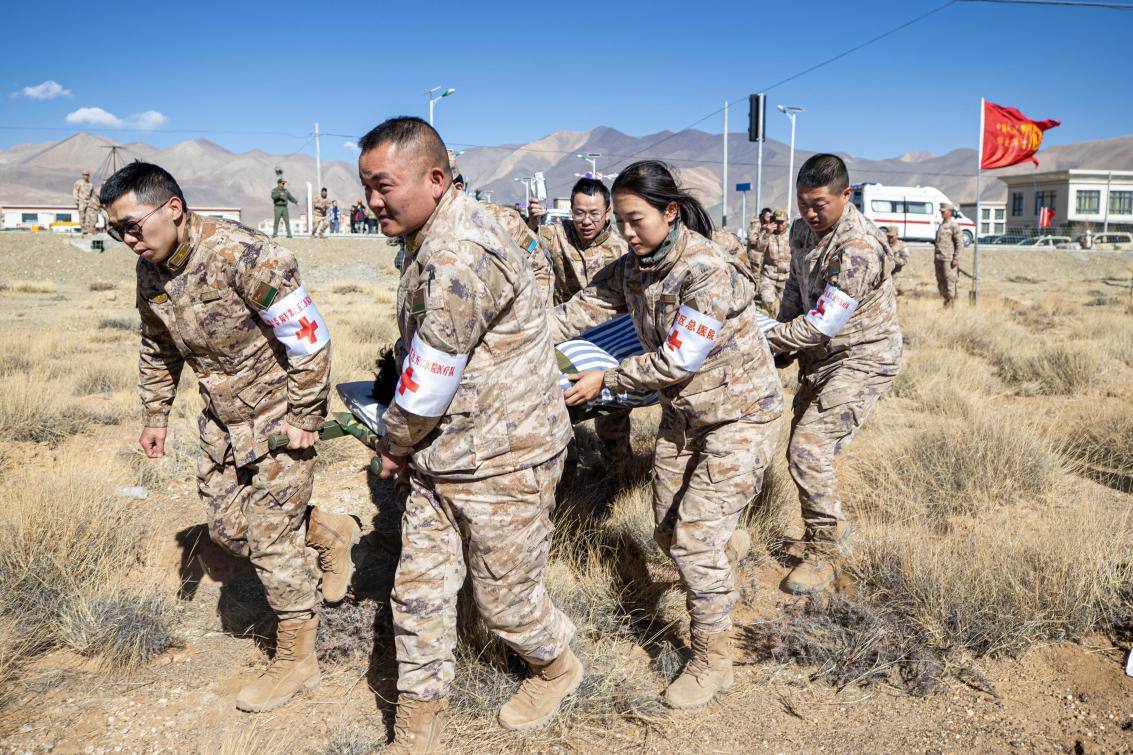 1月9日，日喀則定日縣長所鄉(xiāng)，西藏軍區(qū)總醫(yī)院醫(yī)療隊隊員將受傷村民用擔(dān)架從救護(hù)車準(zhǔn)備抬上直升機(jī)，轉(zhuǎn)運(yùn)至拉薩的西藏軍區(qū)總醫(yī)院救治。人民日報記者張武軍攝