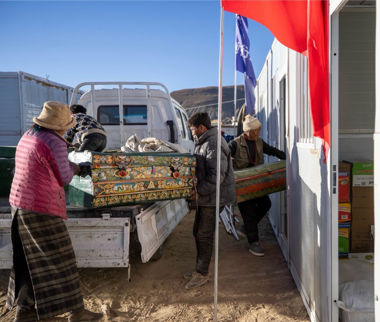 1月11日，西藏定日縣曲洛鄉(xiāng)措昂村，首批入住活動板房的村民正在搬運(yùn)物品，為入住做準(zhǔn)備。人民日報記者張武軍攝