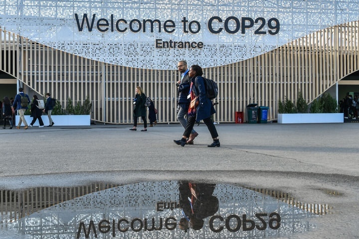 2024年11月15日，在阿塞拜疆首都巴庫(kù)，人們經(jīng)過(guò)聯(lián)合國(guó)氣候變化巴庫(kù)大會(huì)的會(huì)場(chǎng)。新華社記者 曹陽(yáng) 攝