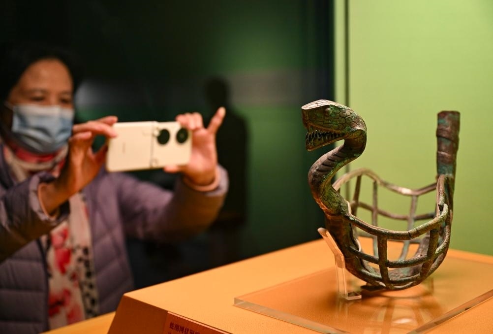 1月14日，觀眾在上海博物館蛇年迎春展拍攝展品蛇綱網(wǎng)狀銅器。新華社發(fā)（陳浩明攝）