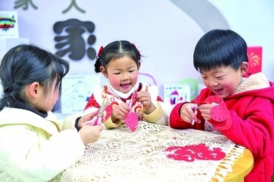 圖為孩子們?cè)诶蠋熤笇?dǎo)下制作蛇年主題剪紙。 新華社記者 徐昱攝