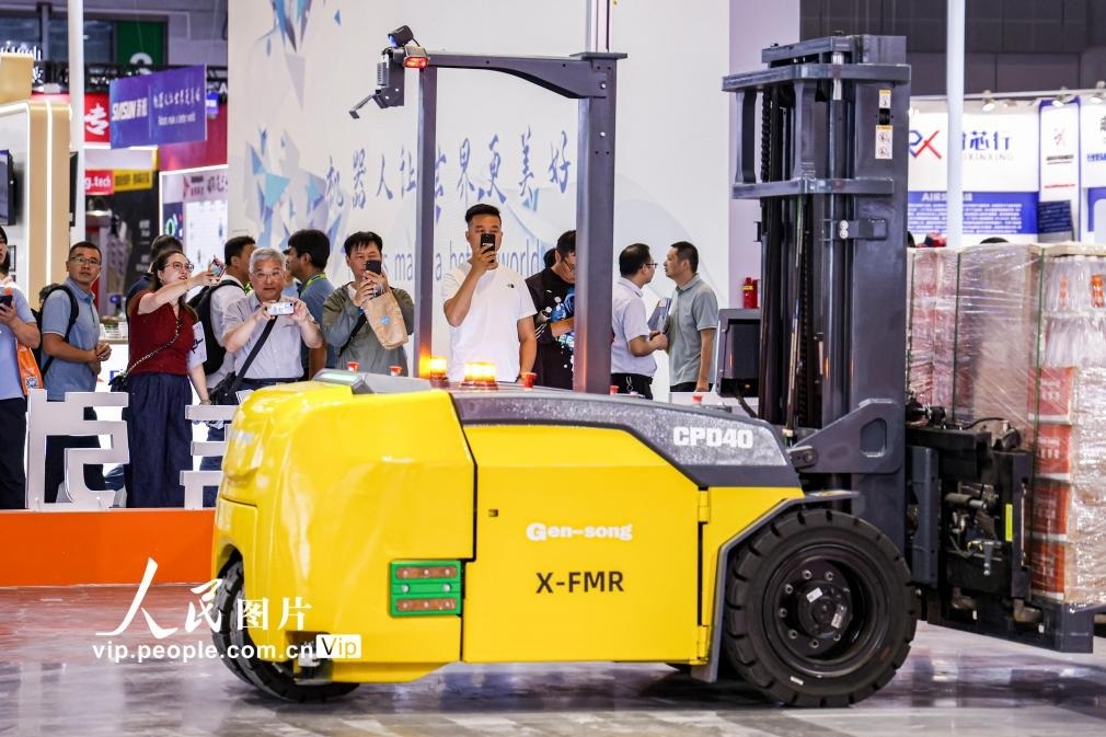 第24屆中國(guó)工博會(huì)現(xiàn)場(chǎng)，觀眾觀看叉取機(jī)器人作業(yè)演示。王初攝（人民圖片網(wǎng)）