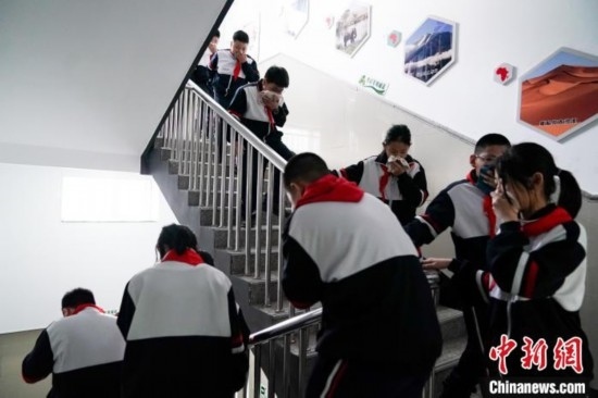  圖為學(xué)生們進行應(yīng)急疏散演練。中新社記者 趙宇航 攝