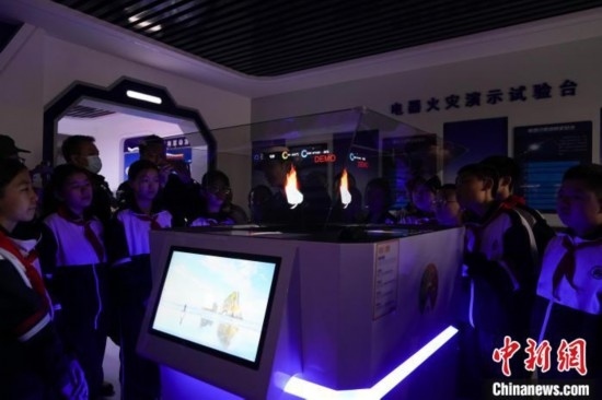 圖為學(xué)生們參觀道里區(qū)消防救援大隊消防科普體驗館內(nèi)幻影成像燃燒三要素實驗臺。中新社記者 趙宇航 攝