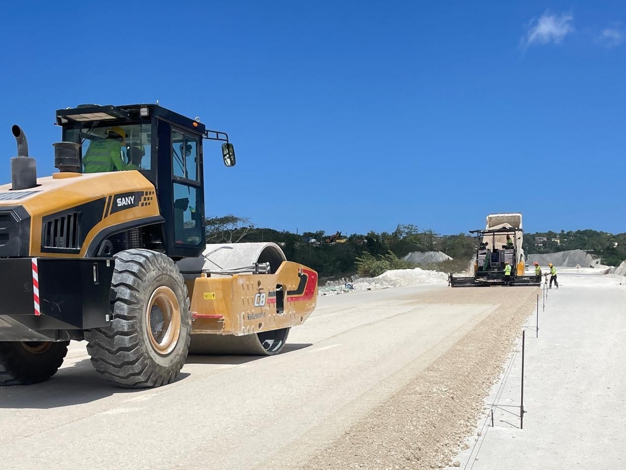 圖為中企承建的牙買加蒙特哥貝繞城路項(xiàng)目基層試驗(yàn)段正在進(jìn)行攤鋪和碾壓施工，相關(guān)施工工作已于日前順利完成。中國(guó)港灣美洲區(qū)域公司供圖