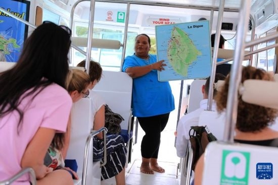 3月15日，一名導(dǎo)游在游艇上為游客介紹塞舌爾拉迪格島。新華社記者 董江輝 攝