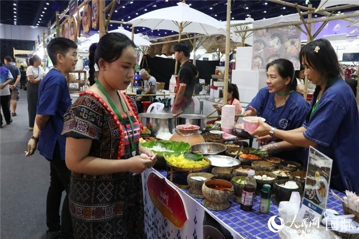 游客在攤位前購(gòu)買特色美食。朱瀟逸攝