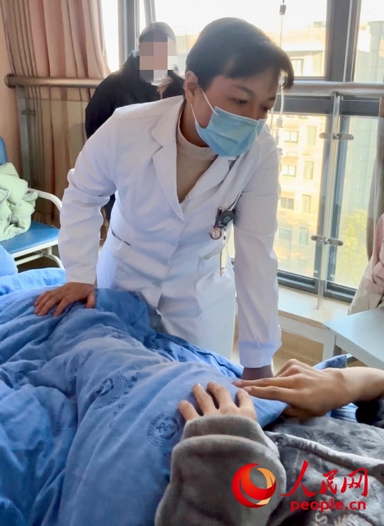 鄧茜查房時(shí)詢(xún)問(wèn)患者情況。人民網(wǎng)記者 金慧慧攝