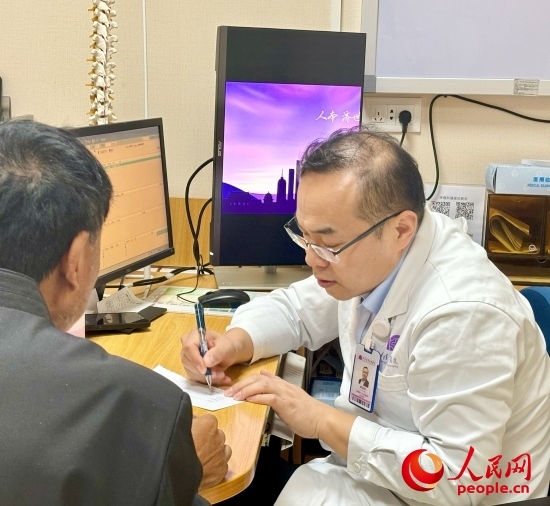 路桂軍接診時(shí)為患者寫(xiě)下用藥提示。人民網(wǎng)記者 金慧慧攝