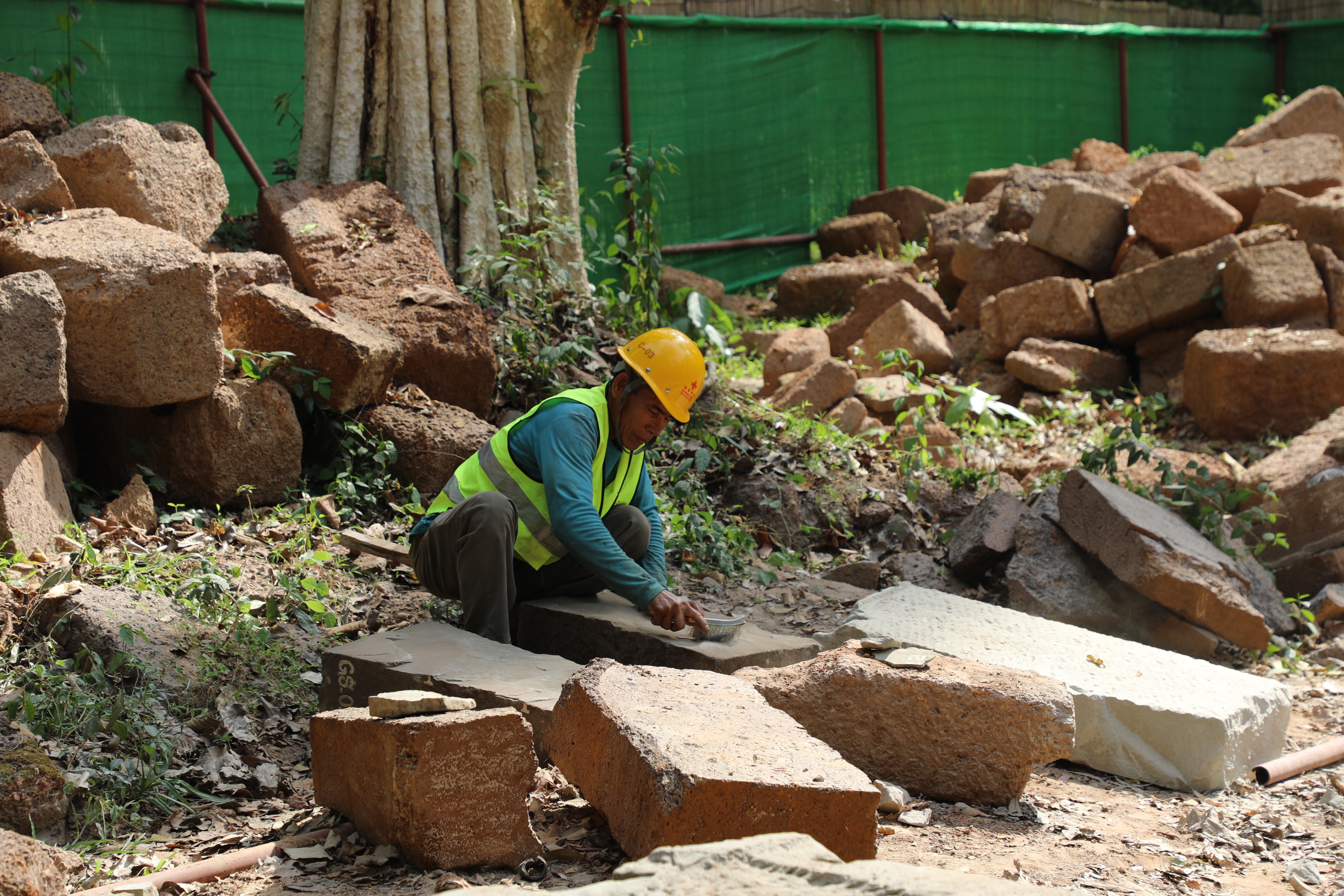 一名柬埔寨工人正在王宮遺址修復(fù)現(xiàn)場(chǎng)工作。（人民日?qǐng)?bào)記者曹師韻 攝）