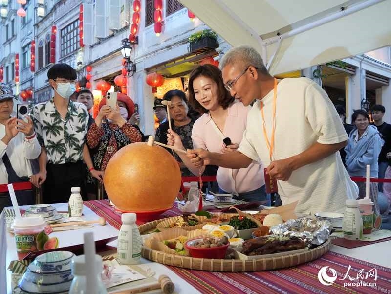 嘉賓品嘗海南傳統(tǒng)美食“煎堆”。人民網(wǎng)記者 張力洋攝