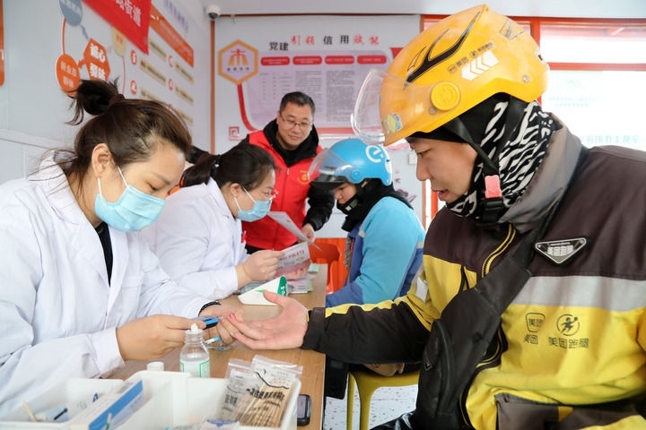 2025年3月5日，志愿者在山東省棗莊市市中區(qū)一工會驛站為外賣員免費測量血糖。新華社發(fā)（王海楠攝）