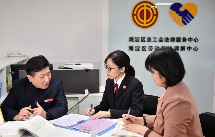 2025年3月6日，在北京市海淀區(qū)總工會勞動爭議調(diào)解中心，海淀區(qū)人民法院法官王琰（中）與該中心工作人員就糾紛化解情況進行溝通。新華社記者 趙婷婷 攝