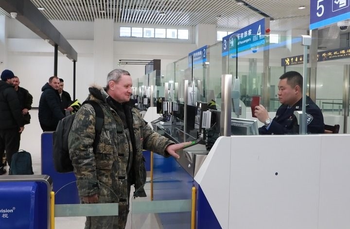 2024年12月10日，在黑河公路口岸旅檢大廳，黑河出入境邊防檢查站民警為首班次客車(chē)入境旅客辦理邊檢通關(guān)手續(xù)。當(dāng)日，中國(guó)黑河公路口岸—俄羅斯卡尼庫(kù)爾干公路口岸旅客運(yùn)輸正式開(kāi)通。新華社發(fā)（劉松攝）