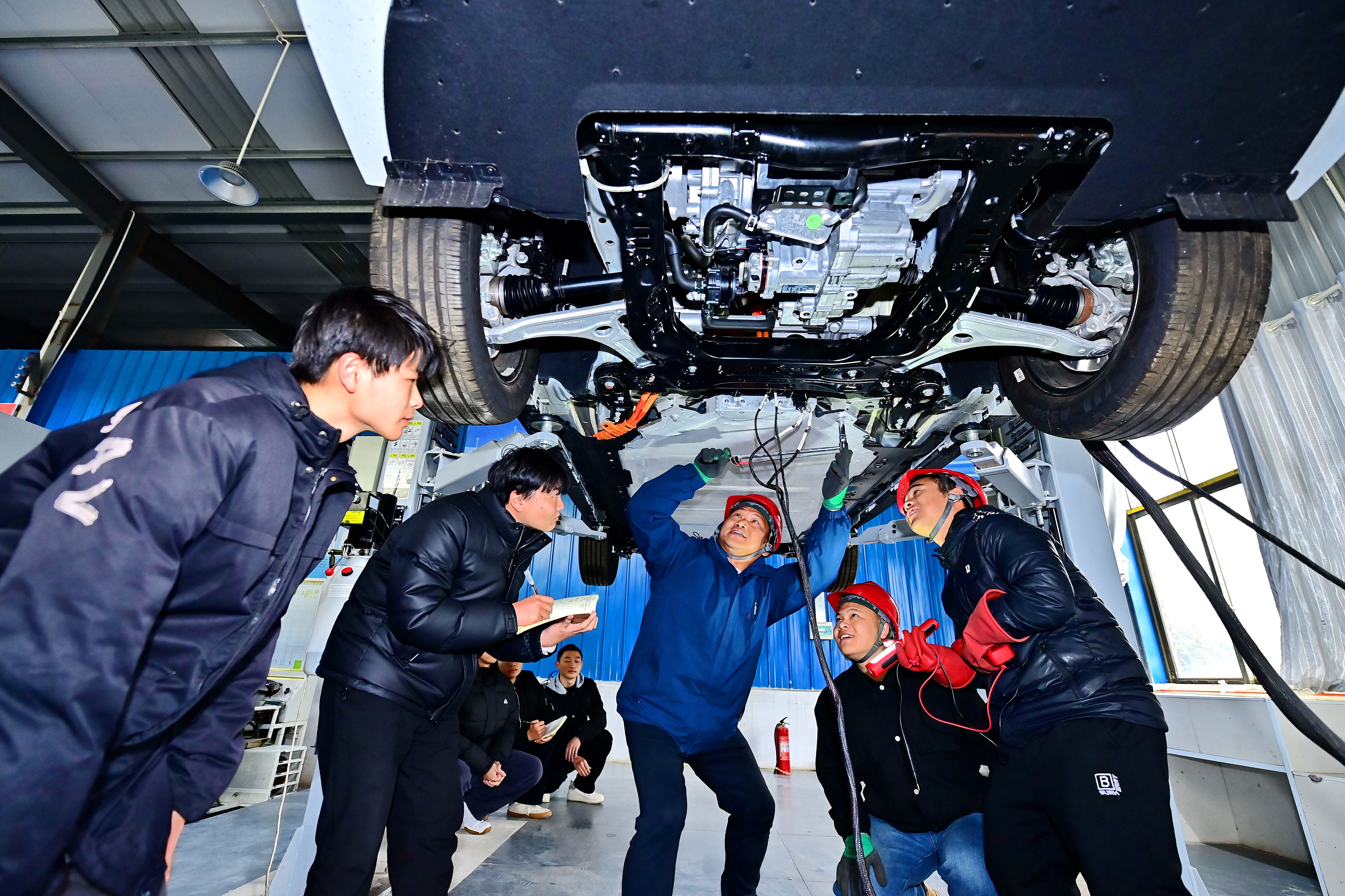 2025年2月，江西省宜春市，豐城市的一所技工學(xué)校實(shí)訓(xùn)基地內(nèi)，新能源汽車運(yùn)維專業(yè)學(xué)生在老師的指導(dǎo)下學(xué)習(xí)新能源汽車電池包檢修技術(shù)。