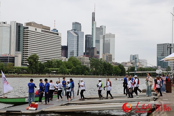 來自美國的快樂龍舟隊(duì)選手們正在登船準(zhǔn)備參賽。人民網(wǎng)記者 劉仲華攝
