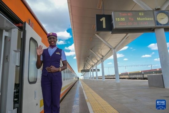 5月31日，在蒙內(nèi)鐵路內(nèi)羅畢站，一名乘務(wù)員在即將開(kāi)往蒙巴薩的E2次列車(chē)旁等候乘客。新華社記者 楊光 攝