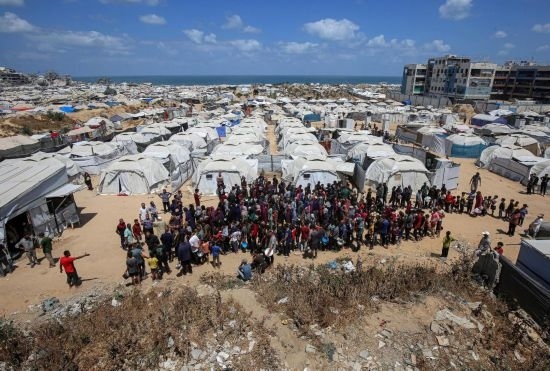 5月28日，人們在加沙城西部的沙提難民營等待領(lǐng)取救助食物。新華社發(fā)（里澤克·阿卜杜勒賈瓦德攝）